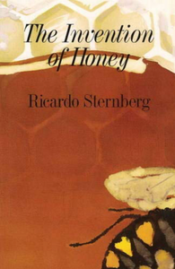 Cover of the book titled The invention of honey by Ricardo Sternberg. On the cover is a illustration of honey comb. Towards the top you can see the honey comb easily since it is in a light yellow and white but most of the cover in in a amber like color representing honey that only lets you see a light outline of the honey comb. In the bottom right corner you can see the bottom half of a black and yellow bee. The text is in black.